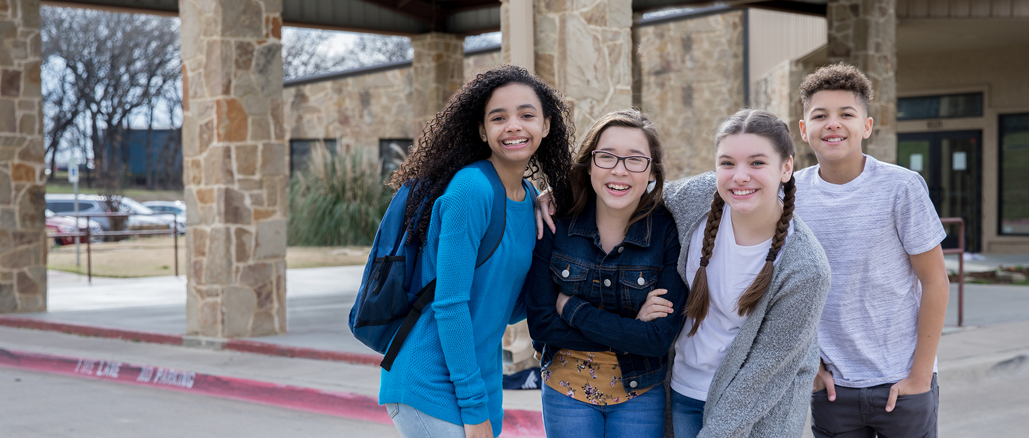 4 middle school students smiling together