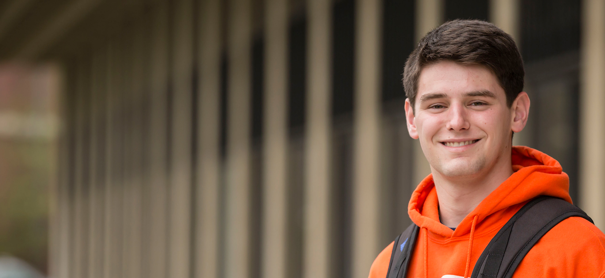 Undergraduate student smiling outside of the College of Education building